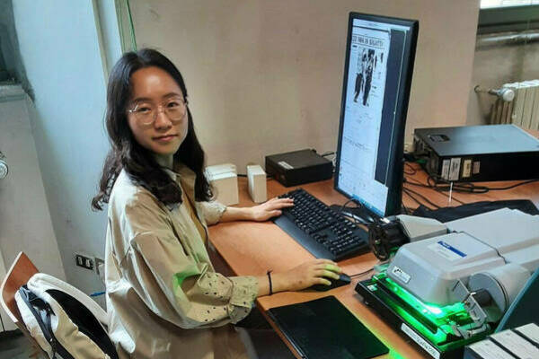 Inha Park examines microfilm archives as part of her research at Biblioteca Sormani in Milan, Italy.