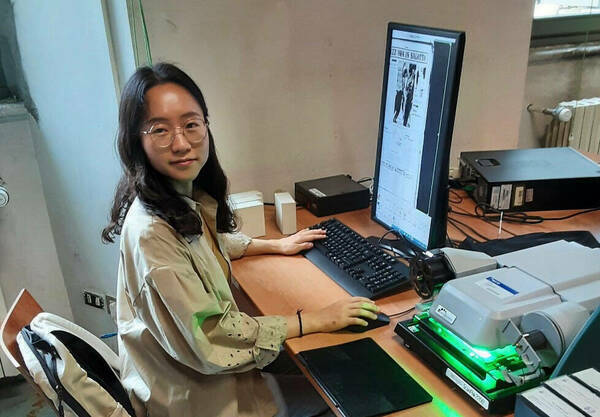 Inha Park examines microfilm archives as part of her research at Biblioteca Sormani in Milan, Italy.